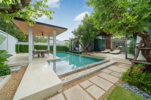a swimming pool in the backyard of a house at Botanica Foresta 4BDR by Villacarte in Ban Phru Champa