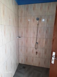 a bathroom with a shower in a wooden wall at Villa Frisi in Palimé +29 photos