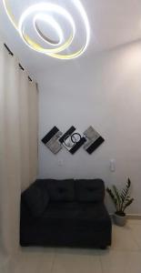 a living room with a black couch and a ceiling at Mini Casa 02 - Próx Aeroporto e Centro Hospitalar in Teresina