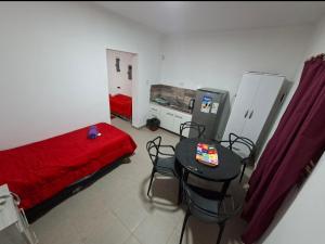 a bedroom with a red bed and a table and chairs at Flor de la Montaña 2 in Fiambalá
