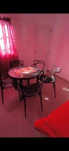 a table and chairs in a room with a red light at Flor de la Montaña 2 in Fiambalá