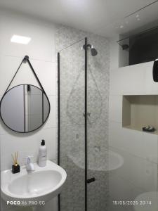 a bathroom with a sink and a shower with a mirror at Mini Casa 02 - Próx Aeroporto e Centro Hospitalar in Teresina