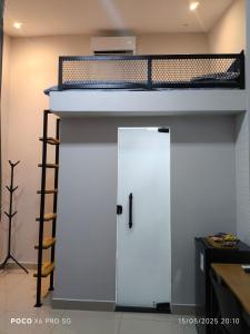 a loft bed with a white door and a ladder at Mini Casa 02 - Próx Aeroporto e Centro Hospitalar in Teresina