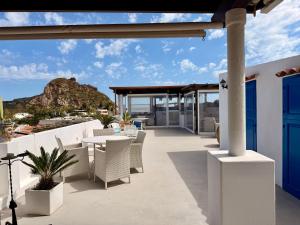 a patio with a table and chairs and a view of the ocean at La Giara in Vulcano