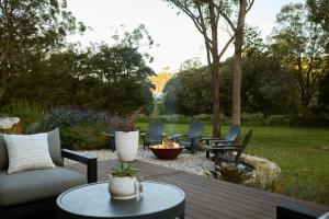 a patio with a couch and chairs and a table at The Pavilion Wamberal in Wamberal