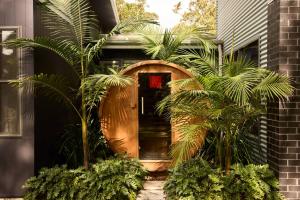 a front door of a house with palm trees at The Pavilion Wamberal in Wamberal