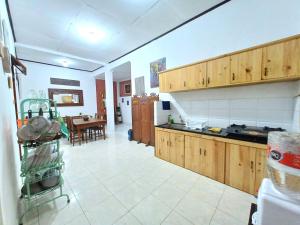 a kitchen with wooden cabinets and a table in it at Ghanaya Guesthouse in Ngaglik