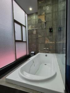a large white tub in a bathroom with a shower at Jason Residencia One Hotel in Phnom Penh +17 photos