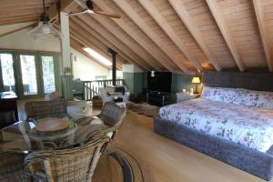 a bedroom with a bed and a table and chairs at Valhalla The Loft (Oceanfront Hot tub) in Salt Spring Island