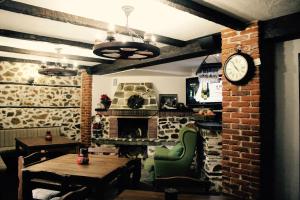 a dining room with a table and a fireplace at Kutsinska House in Progled