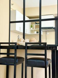a dining room table with two chairs and a mirror at AnR Condo at Avida Towers in Cagayan de Oro