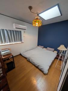a bedroom with a white bed in a blue wall at アトイエ-Atoie- in Odawara