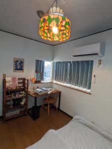 a bedroom with a bed and a desk and a chandelier at アトイエ-Atoie- in Odawara