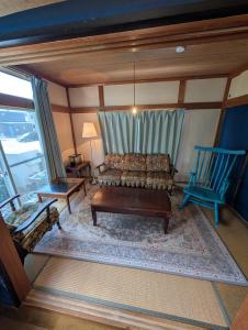 a living room with a couch and a blue chair at アトイエ-Atoie- in Odawara