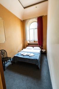 a bedroom with a bed with two towels on it at Mini-hotel Franko Park in Lviv