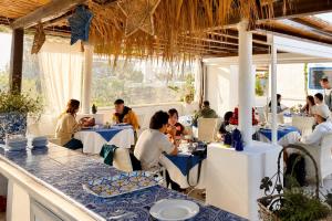 a group of people sitting at tables in a restaurant at La Giara in Vulcano +76 photos