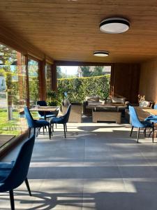 a patio with blue chairs and tables and windows at Pokoje Hotelowe Wiktoria in Goczałkowice Dolne