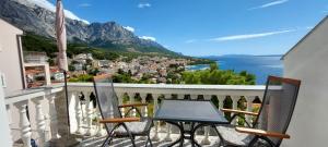a table and two chairs on a balcony with a view at Apartman Saric K&M in Baška Voda
