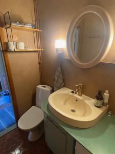 a bathroom with a sink and a toilet and a mirror at ArtBeat Downtown in Turku