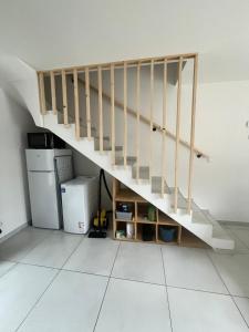 a staircase in a living room with a refrigerator at Maison mitoyenne in Gignac-la-Nerthe