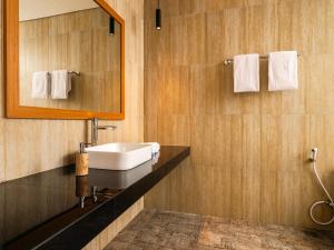 a bathroom with a sink and a mirror at Prawara Uluwatu in Uluwatu +9 photos