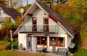 a small white house with a balcony on a hill at Seeparkurlaub, Hessen in Kirchheim