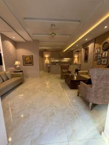 a large living room with couches and a table at Shelton Hotel Gulberg in Lahore +10 photos