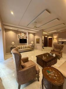 a large living room with a couch and a table at Shelton Hotel Gulberg in Lahore