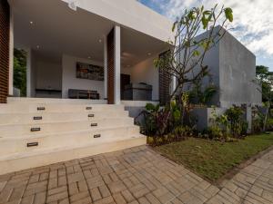 an exterior view of a house with a wooden retaining wall at Prawara Uluwatu in Uluwatu