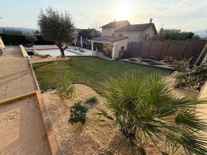 a house with a yard with plants and a house at Ô'Bon'Endroit - Piscine, Calme, 20 min Lyon in Givors