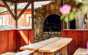 a wooden bench in front of a stone oven at BiesChatki in Wetlina