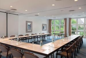 a large room with tables and chairs and windows at Sunday Hotel Flensburg in Flensburg