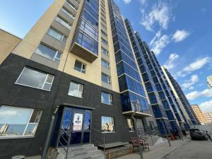 a tall building with glass windows on a street at Modern Luxury Debut - Untouched in Ulaanbaatar
