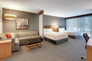 a hotel room with two beds and a couch at Hyatt Place Milwaukee Downtown in Milwaukee +123 photos