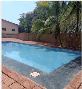 a swimming pool with blue water in a yard at Hotel Sai Palkhi Niwara in Shirdi