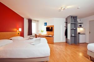 een hotelkamer met twee bedden en een bureau bij Séjours & Affaires Lyon Saxe-Gambetta in Lyon