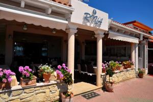 a restaurant with potted flowers on a patio at Novalja Zrce Apartment in Novalja