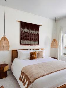 a bedroom with a large white bed and a window at Gypsea Rest Private Villa in Nusa Lembongan