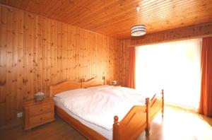 ein Schlafzimmer mit einem Bett mit einer Holzwand in der Unterkunft Haus Alpentraum in Randa