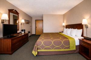 a hotel room with a bed and a flat screen tv at Super 8 by Wyndham Gallup in Gallup +26 photos