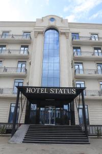 a hotel sign in front of a building at STATUS HOTEL in Qarshi