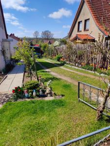 a yard with a fence and a house at Gästehaus am Teich in Raben Steinfeld