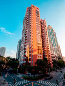 a tall orange building in a city with a street at Prince Plaza II Condotel in Manila