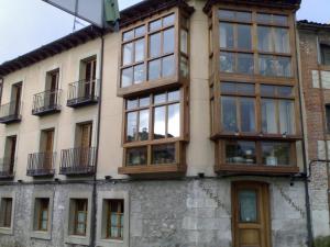 un edificio con muchas ventanas a un lado. en Hostal San Francisco, en Cuéllar