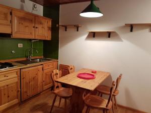 een keuken met een houten tafel met een rode plaat erop bij Appartamento Camporosso in Tarvisio