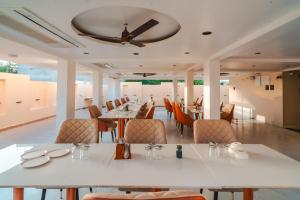 a dining room with tables and chairs and a ceiling at Travinities Hotel Shree Ji Palace in Ujjain