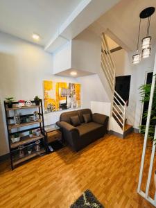 a living room with a couch and a staircase at Breena & Dhanie's Haven I in Labac