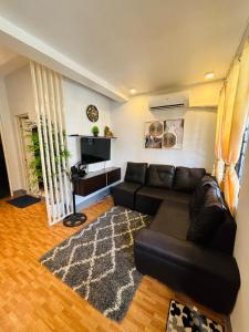 a living room with a black leather couch and a rug at Breena & Dhanie's Haven I in Labac
