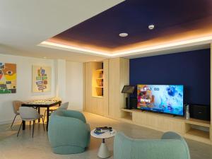 a living room with a tv and a table and chairs at Eri Maldives in North Male Atoll