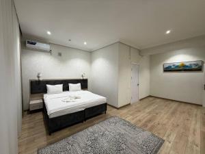 a bedroom with a large white bed in a room at STATUS HOTEL in Qarshi +47 photos